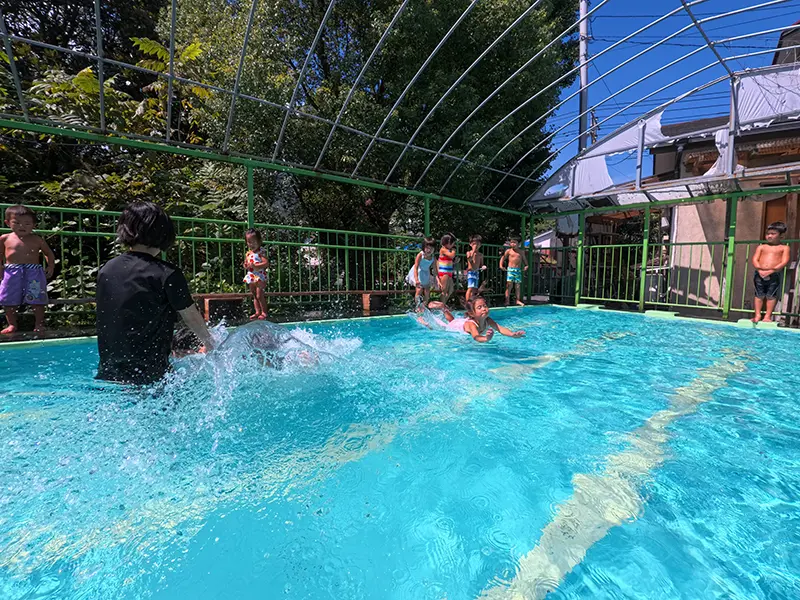 園のプールで水遊びを楽しむ子どもたちの様子